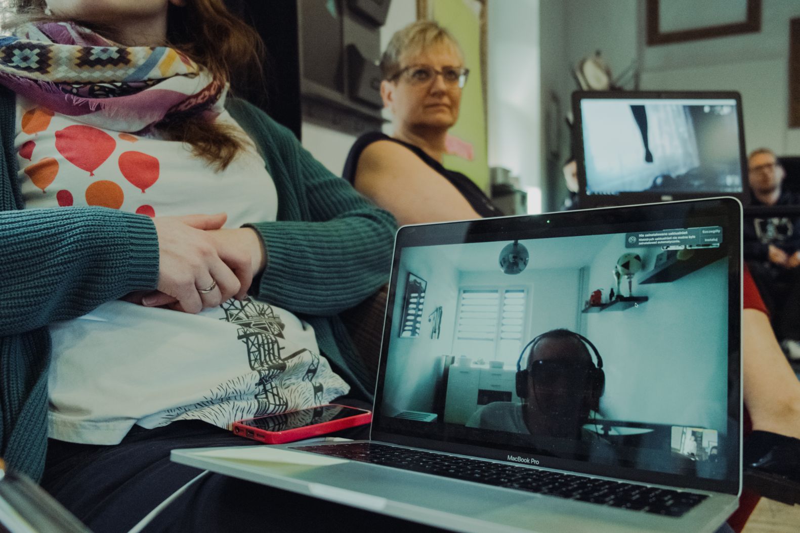 na ekranie laptopa mężczyzna z niepełnosprawnością w specjalnych okularczący się zdalnie za pomocą komunikatora intenetowego z koleżankami z pracyach, łą
